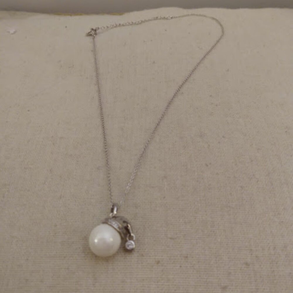 Faux pearl snowman head with hat and rhinestone trim.